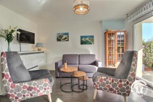 a living room with two chairs and a couch at Le randonneur in Pleubian