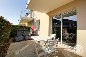 a white table and chairs sitting outside of a house at Le randonneur in Pleubian