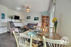 a dining room and living room with a table and chairs at Le randonneur in Pleubian