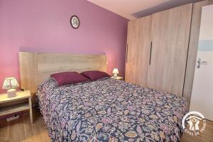 a bedroom with a bed and a clock on the wall at Le randonneur in Pleubian