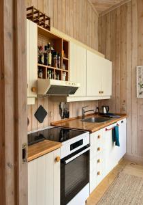a kitchen with white cabinets and a sink at Architect's House With Panoramic View In Lumsås in Lumsås