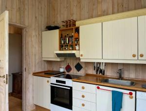 a kitchen with white cabinets and a sink at Architect's House With Panoramic View In Lumsås in Lumsås