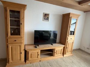 a large wooden entertainment center with a flat screen tv at Karwendel Lodge in Mittenwald