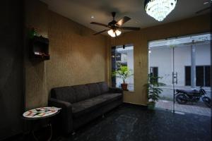 a living room with a couch and a ceiling fan at Hotel Mantra Inn in Haridwār