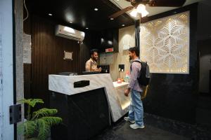 two men standing at a counter in a restaurant at Hotel Mantra Inn in Haridwār