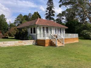 a small house with a deck on the grass at Mount Booralee Estate in Blackheath +14 photos
