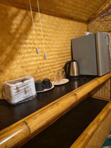 a kitchen counter with a microwave and cups and plates at Fa eap Bungalow in Ko Lanta Yai