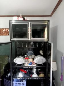 a cabinet with plates and dishes in it at pondok tegal jero in Jatiluwih