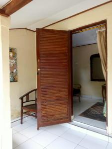 a wooden door in a room with a chair at pondok tegal jero in Jatiluwih