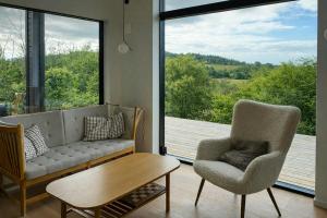 a living room with a couch and two chairs and a table at Summer House On Hillside Plot By Sejerø Bay in Fårevejle