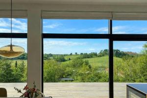 a room with a large window looking out at the countryside at Summer House On Hillside Plot By Sejerø Bay in Fårevejle