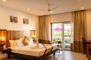 a hotel room with a bed and a balcony at River Deck Baga Beach Front in Calangute