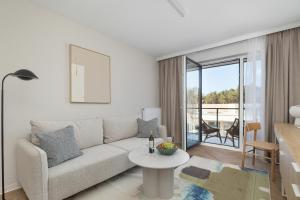 a living room with a couch and a table at Essense Baltic Resort & SPA in Dziwnów