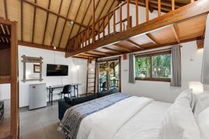 a bedroom with a bed and a couch and a desk at The Social - Begadang Gili Air in Gili Islands