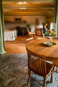 a living room with a wooden table and a bed at Restored House With Art In Österlen in Borrby