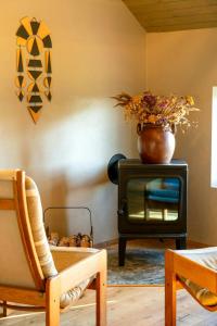 a living room with a vase on top of a stove at Restored House With Art In Österlen in Borrby +16 photos