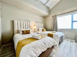 two beds in a room with a window at Rustic Hills #30 in Swakopmund