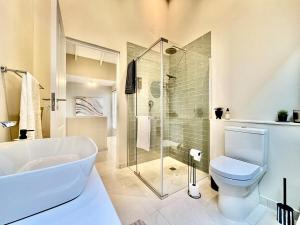 a bathroom with a tub and a toilet and a shower at Rustic Hills #30 in Swakopmund