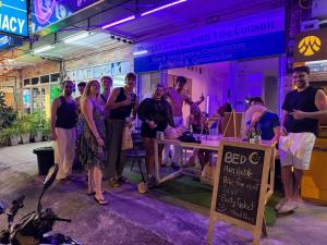 a group of people standing around a table in a room at Lunar Nomad Hostel in Ban Nua