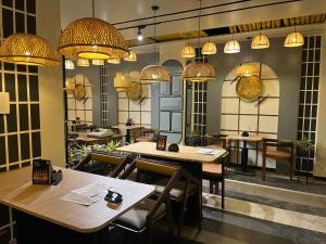 a restaurant with tables and chairs and chandeliers at nKAaSA hotel Personal Suites in Raxaul