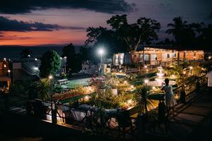 a woman standing on a balcony looking at a garden at night at The Mountain side Floating Villa in Baybay