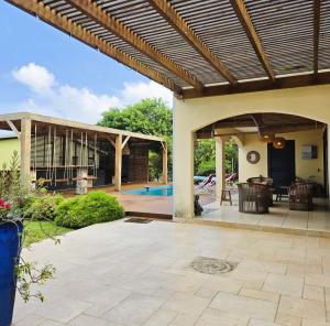 an outdoor patio with a wooden pergola at Villa Ö Schandél in Saint-Paul