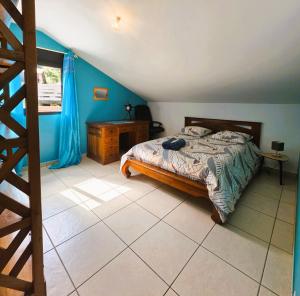 a bedroom with a bed and a table and a window at Villa Ö Schandél in Saint-Paul