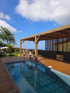 a swimming pool on the roof of a house with a wooden deck at Villa Ö Schandél in Saint-Paul