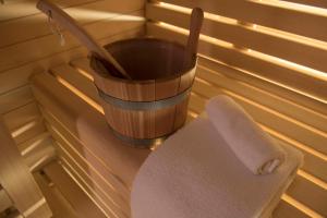 a bench in a sauna with a bucket and a paddle at Expo Hotel Milan in Parabiago