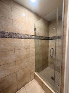 a bathroom with a shower with a glass door at Stallion Motel Los Angeles in Los Angeles