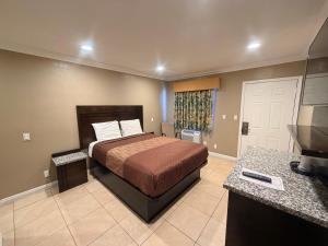 a hotel room with a bed and a television at Stallion Motel Los Angeles in Los Angeles