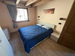 a small bedroom with a blue bed and a window at Coudrey 2 in Doues