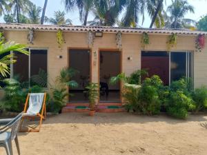 a house on the beach with palm trees at Holiday Homestay Beach Rooms Deep Diving & Light House & Watersports Tarkarli in Bhogwe