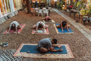 a group of people doing yoga on the ground at The Yard Bangkok Hostel in Bangkok