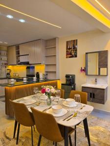 a dining room with a table with chairs and a kitchen at Monte Opulent Haven in Eldoret