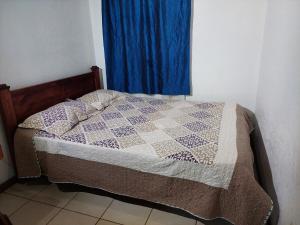 a bedroom with a bed with a blue curtain at Apartamento 7 Tec in Cartago +1 photo