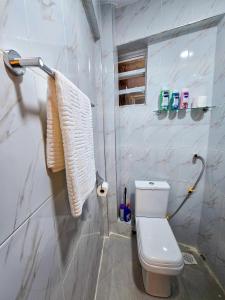 a white bathroom with a toilet and a shower at Monte Opulent Haven in Eldoret