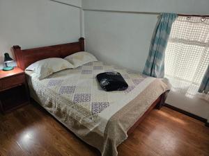 a bedroom with a bed with a purse on it at Apartamento 7 Tec in Cartago