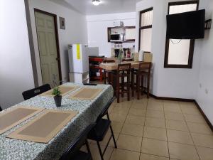 a kitchen with a table with chairs and a refrigerator at Apartamento 7 Tec in Cartago