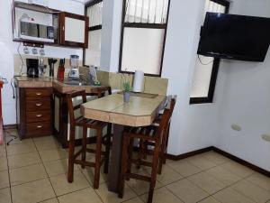 a kitchen with a table and some chairs and a tv at Apartamento 7 Tec in Cartago