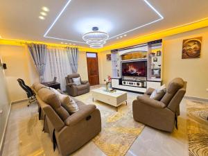 a large living room with couches and a tv at Monte Opulent Haven in Eldoret +9 photos