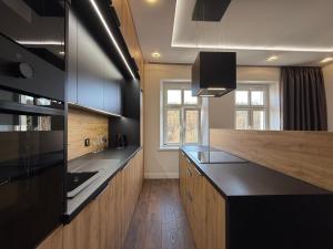 a kitchen with black counters and a counter top at Apartament GreenHills 3 in Wałbrzych