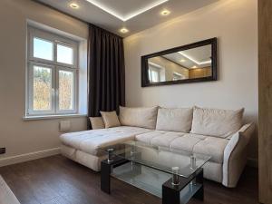 a living room with a couch and a mirror at Apartament GreenHills 3 in Wałbrzych