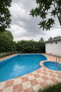 a large swimming pool in a yard with trees at CASA NOVA Villa in Noida