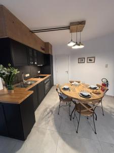 a kitchen with a wooden table and chairs in a room at Bivouac 101 in Bastogne +1 photo