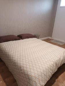a bed with a white comforter in a bedroom at Comfortable studio dans une maison au calme in Bellerive-sur-Allier