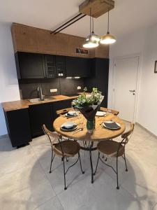 a kitchen with a wooden table with chairs and a sink at Bivouac 101 in Bastogne