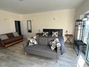 a bedroom with a bed and a couch at Sharpley Hall Garden Studio not far from Seaham Beach offering Quiet Private Stay with Secure Parking in Seaham