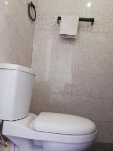 a white toilet in a bathroom with a towel at Meegoda Villa in Kalutara