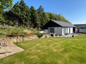 a yard with a house and a stone wall at Sharpley Hall Garden Studio not far from Seaham Beach offering Quiet Private Stay with Secure Parking in Seaham